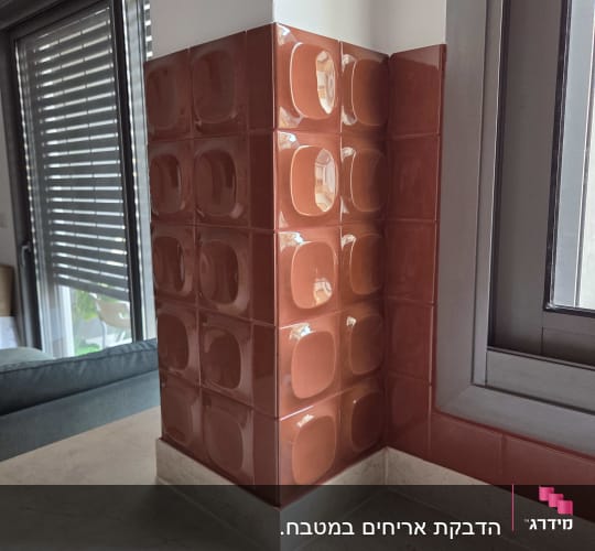 חיפוי קיר דקורטיבי באריחי קרמיקה תלת-ממדיים מבריקים מעל משטח עבודה